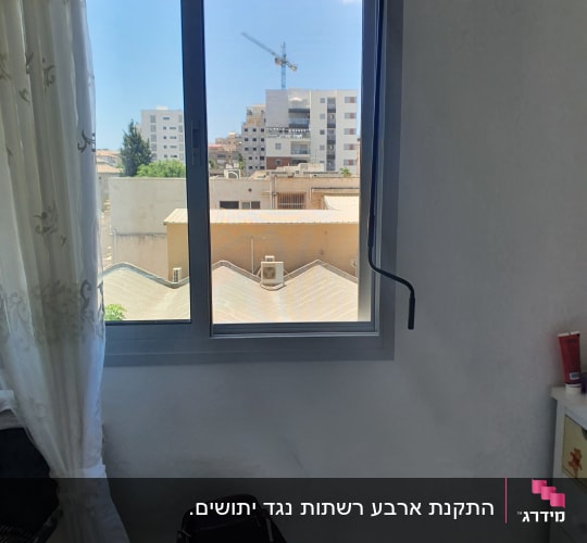 חלון אלומיניום עם נוף עירוני ברקע